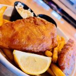 A plate of fish and chips with lemon wedges., Bevy's tavern, West Des Moines